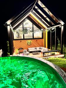 a large green swimming pool in front of a house at STODOLA U Františka in Dolní Bojanovice