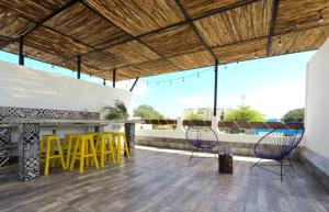 a patio with chairs and a bar on a roof at Valentina Suites by Las Flores Vacation Rentals in Playa del Carmen