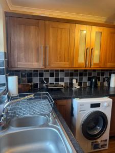 a kitchen with a sink and a washing machine at Spacious 3 bed semi-detached house in Luton