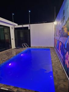 a large blue swimming pool in a room at night at Casa María in Tonatico