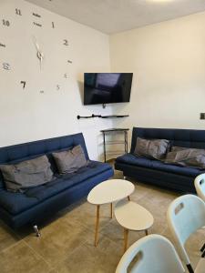 a living room with two blue couches and a tv at Casa María in Tonatico