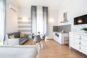 a bedroom with a bed and a kitchen with a couch at Camera Tua - Falloppio 44 Rooms in Padova