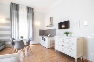a white kitchen with a white dresser and a table at Camera Tua - Falloppio 44 Rooms in Padova