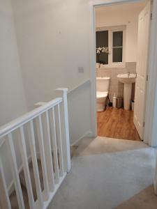 a bathroom with a staircase and a toilet and a sink at Anchored Homes in Spalding +12 photos