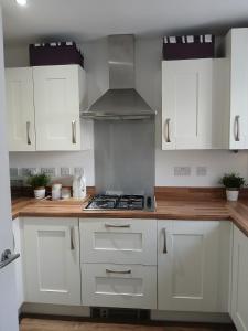 a kitchen with white cabinets and a stove top oven at Anchored Homes in Spalding
