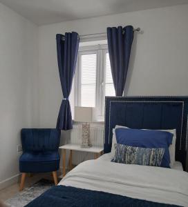 a bedroom with a bed and a blue chair at Anchored Homes in Spalding