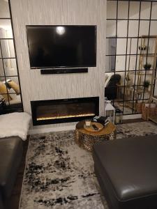 a living room with a fireplace and a flat screen tv at Anchored Homes in Spalding
