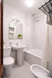 a white bathroom with a sink and a toilet and a tub at Pensión Rey in Isla de Arosa +73 photos