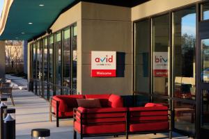 a building with two red couches outside of it at avid hotel Redding by IHG in Redding