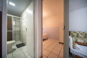a bathroom with a toilet and a shower at Mares e Flores by OlaMar Bombinhas in Bombinhas +65 photos