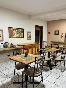 a dining room with wooden tables and chairs at Hotel Norte Sul in Campo Grande
