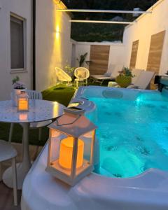 a small swimming pool with a table and a lighted lantern at Elegance Paema, a 290mt dalle Spiagge! in San Lucido