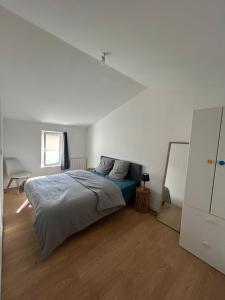 a bedroom with a bed in a white room at La Petite Maison in Toutlemonde
