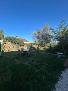 a picnic table and chairs in a field of grass at La Petite Maison in Toutlemonde
