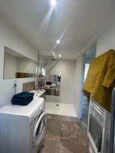 a white laundry room with a washer and a bathroom at La Petite Maison in Toutlemonde