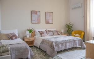 a bedroom with two beds and a table and chairs at Actinia Accommodation in Alghero +69 photos