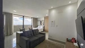 a living room with a couch and a bed at Studio Aconchegante com Vista do 33º Andar in Campo Grande