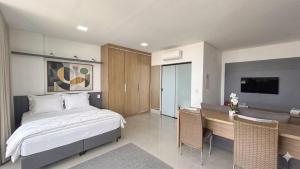 a bedroom with a bed and a desk in it at Studio Aconchegante com Vista do 33º Andar in Campo Grande +13 photos