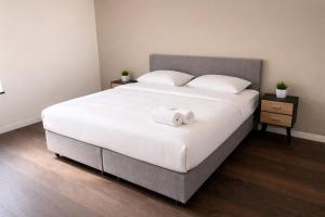 a bedroom with a large bed with two towels on it at La Vie En Rose in Muno