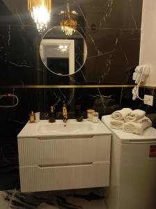 a bathroom with a white sink and a mirror at Gloria Golden Suite- Luxury&Designe Experience in Oradea +33 photos