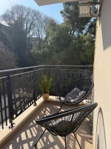 a balcony with a chair and a plant on it at Bright Apartment with Balcony near Bus and Train in Mostar