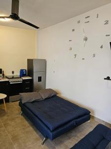 a bedroom with a bed and a clock on the wall at Casa María in Tonatico