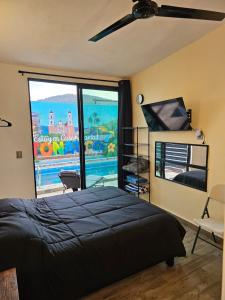 a bedroom with a bed and a large window at Casa María in Tonatico