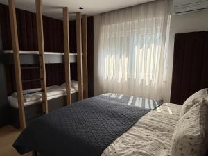 a bedroom with two bunk beds and a window at Bright Apartment with Balcony near Bus and Train in Mostar