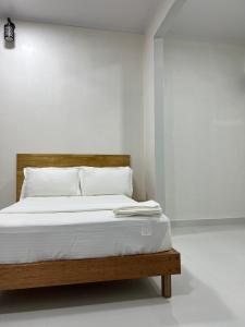 a bedroom with a bed with white sheets and white pillows at Athireege in Manadhoo