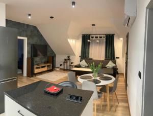 a kitchen and living room with a table and chairs at Szumny Apartment 13a in Brzozówka
