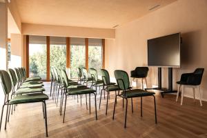 a room with a bunch of chairs and a flat screen tv at Valle Benedetta Retreat Center in Livorno