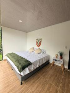 a bedroom with a large bed and a table at Cabañas Agroturistica la Polkca - Experiencia Cafetera in Líbano