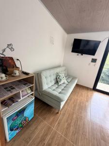 a living room with a couch and a flat screen tv at Cabañas Agroturistica la Polkca - Experiencia Cafetera in Líbano