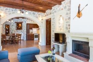 a living room with a fireplace and a tv at Villa Asigonia with Heated Pool & Whirlpool in Asigonía