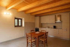 a kitchen with a wooden table and chairs at Resort Helenia in Caulonia +5 photos