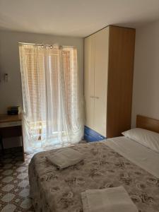 a bedroom with a bed and two large windows at Costa House in Cefalù