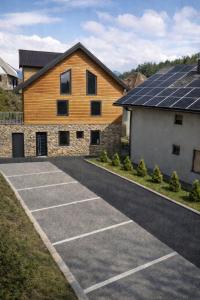 a parking lot with a house with solar panels on it at ELAFON Lodge in Kolašin