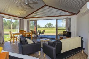 a living room with a couch and a dining room at Wallaby Lodges in Pokolbin