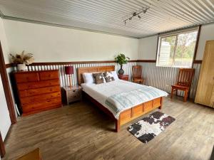 a bedroom with a bed and a dresser at Wallaby Lodges in Pokolbin
