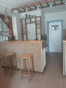 a bar with two stools and a counter in a restaurant at L'auberge du Houx in La Houssière +12 photos