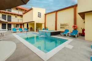 a patio with a swimming pool with chairs and a table at La Pinta Hotel in Ensenada