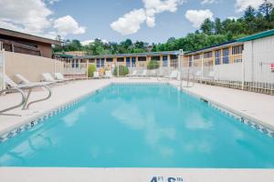 a large swimming pool with chairs and a building at Travelodge by Wyndham Ruidoso in Ruidoso