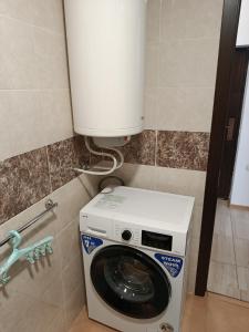a washer and dryer in a small bathroom at Дунав апарт Danube apart in Vidin