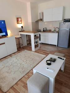 a kitchen with white cabinets and a white table at Дунав апарт Danube apart in Vidin