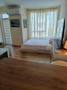 a bedroom with a bed and a large window at Дунав апарт Danube apart in Vidin