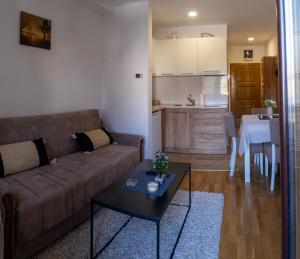 a living room with a couch and a table and a kitchen at Mali Raj in Zlatibor