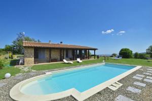 a villa with a swimming pool in front of a house at Villa Borgiano - Happy Rentals in Scansano