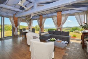 a living room with white furniture and large windows at Villa Borgiano - Happy Rentals in Scansano