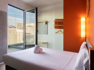 a bedroom with a bed and a large window at Ibis Budget Madrid Centro Lavapies in Madrid