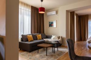 a living room with a couch and a table at Habitat Suites II in Craiova